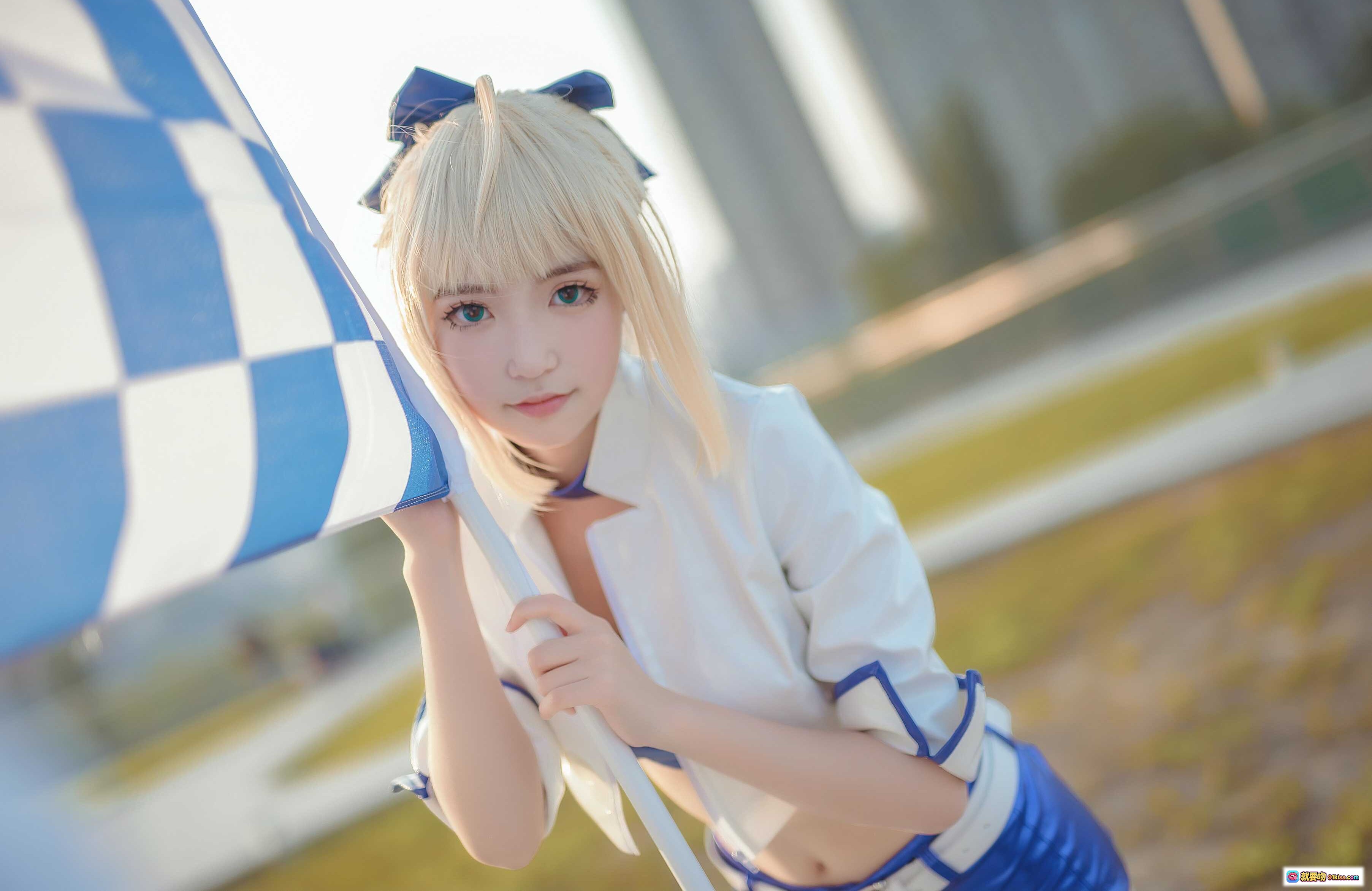 图片[2] - 阿尔托莉雅赛车服cosplay写真｜蓝白制服+短裤+长靴｜金发双马尾造型｜户外玻璃幕墙背景 - 就要吻