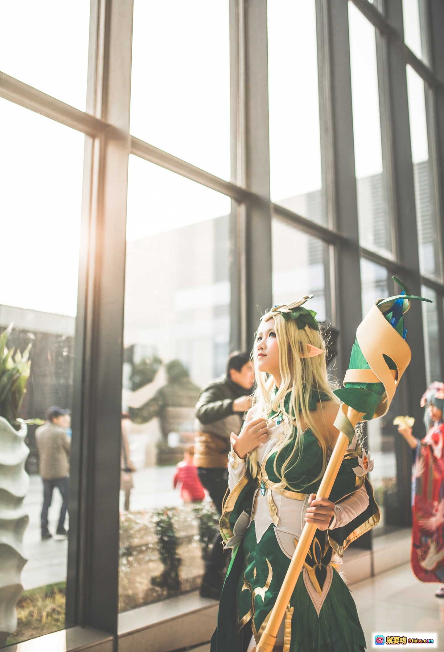 图片[1] - 精灵少女Cosplay王昭君 绿金华丽服饰 手持法杖 窗边逆光写真 二次元动漫角色扮演 精致妆容假发 优雅姿态室内拍摄 - 就要吻